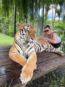 A lady posing for a photograph with a tiger.