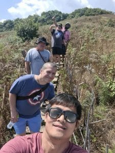 A group of people smiling and posing for a photo while on a walk.
